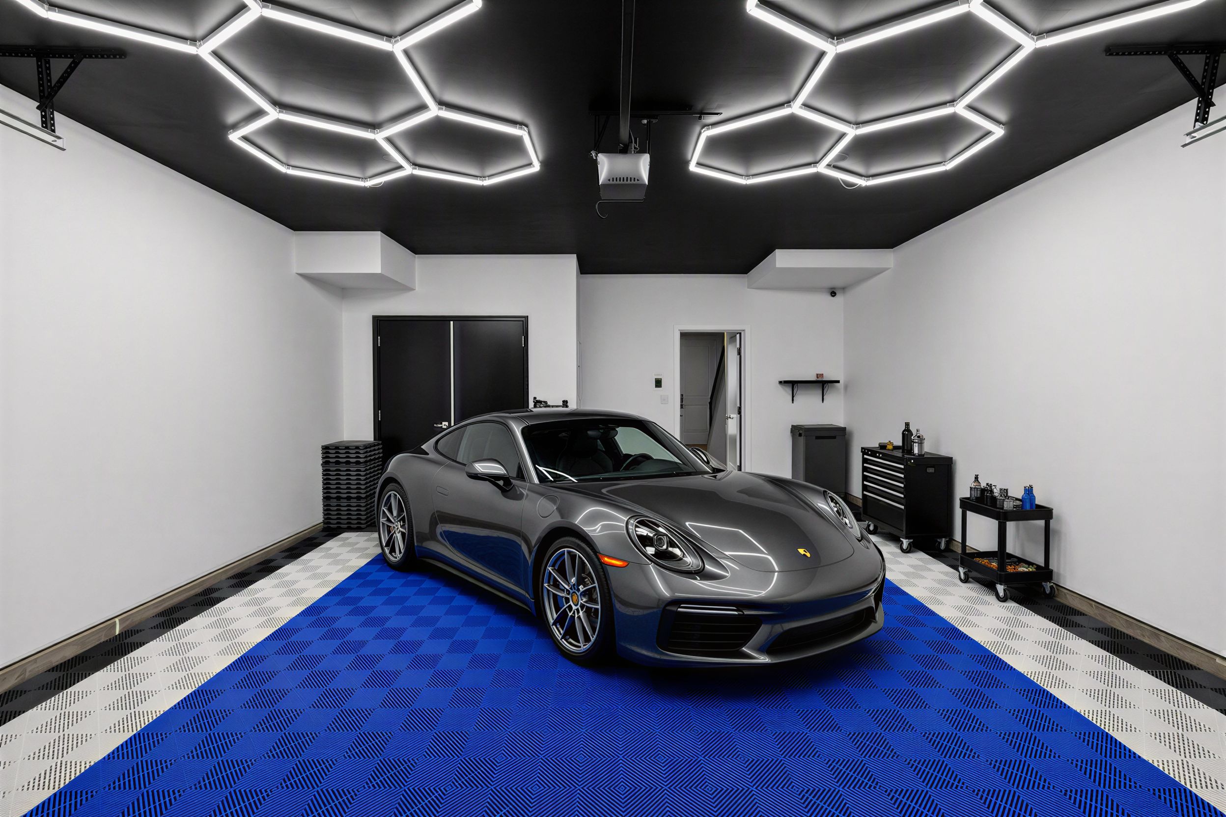 Showcase garage with a sports car, hexagon LED ceiling lighting, and blue checkered floor